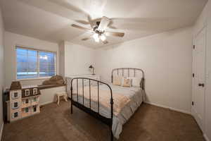 Carpeted bedroom featuring baseboards and ceiling fan