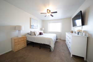Carpeted bedroom with baseboards and a ceiling fan