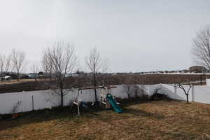 Fenced backyard featuring a playground