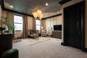 Living area with crown molding, carpet floors, and a chandelier