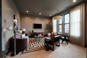 Living area with a decorative wall, recessed lighting, and light tile patterned floors