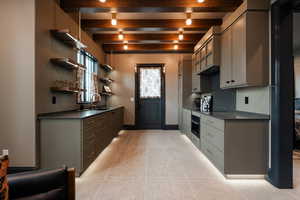 Kitchen featuring open shelves, beam ceiling, oven, light tile patterned floors, and gray cabinetry