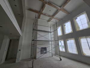Staircase featuring high coffered ceiling