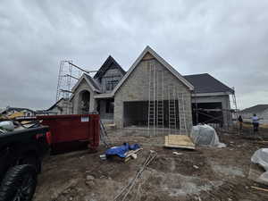 View of front facade featuring stone siding and a patio area