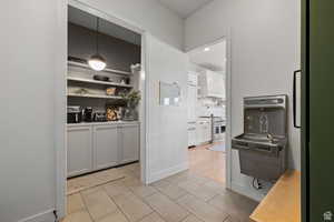 Kitchen featuring white cabinetry, range with two ovens, tasteful backsplash, decorative light fixtures, and wood counters