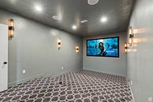 Home theater room with recessed lighting and baseboards