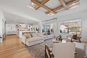 Living room with coffered ceiling, recessed lighting, and light wood-style floors