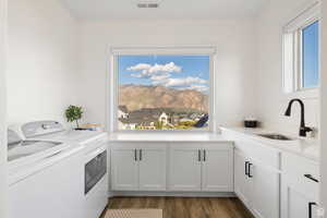 Laundry area featuring separate washer and dryer, dark wood-type flooring, cabinet space, and a mountain view