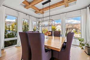Sunroom / solarium with coffered ceiling, plenty of natural light, a mountain view, and suspended lighting