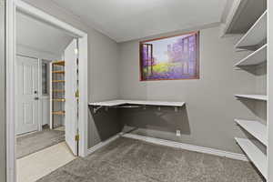 Walk in closet with light colored carpet and light floors
