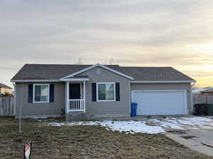 View of front of home with roof with shingles, driveway, and a garage