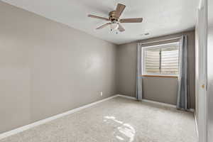 Unfurnished room featuring carpet floors, a ceiling fan, and a textured ceiling