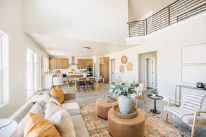 Living room with light wood finished floors, a high ceiling, and recessed lighting