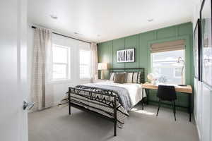 Carpeted bedroom with a decorative wall and recessed lighting