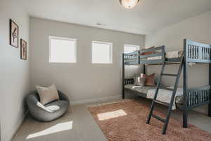 Bedroom with light colored carpet and baseboards