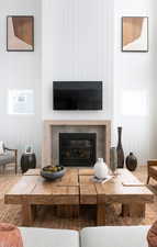 Living area featuring a glass covered fireplace, wood finished floors, and wooden walls