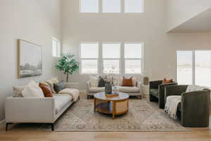 Living room with light wood finished floors and a high ceiling