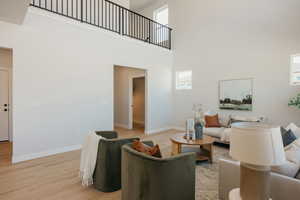 Living area featuring light wood-type flooring and a high ceiling