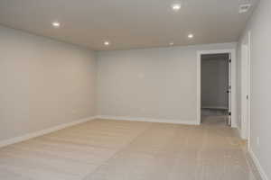 Empty room featuring light carpet and recessed lighting