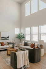 Living area featuring light wood-style flooring and a high ceiling