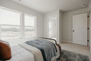 Bedroom with light colored carpet and baseboards