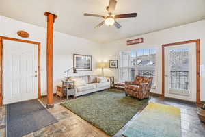 Living room with stone tile floors and ceiling fan