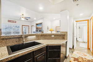 Kitchen featuring ceiling fan, dark wood finish cabinetry, open floor plan, and recessed lighting