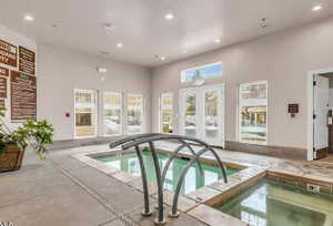 View of swimming pool with a hot tub, a pool, and french doors