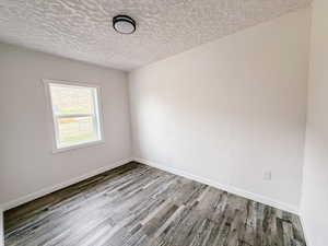 Spare room with a textured ceiling and wood finished floors