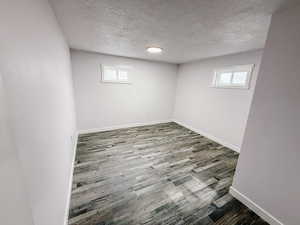 Basement with a textured ceiling and wood finished floors