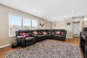 Living area with light wood-style floors and recessed lighting