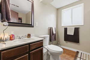 Half bathroom featuring vanity and light wood finished floors