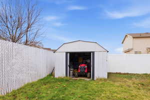 View of shed with a fenced backyard