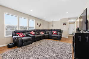 Living room with light wood-style floors and recessed lighting