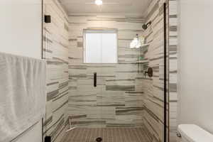 Bathroom featuring toilet and a stall shower