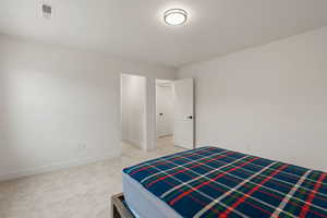 Bedroom with light carpet and a textured ceiling
