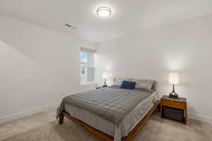 Bedroom with light colored carpet and a textured ceiling