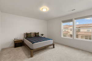 Bedroom featuring light carpet and baseboards