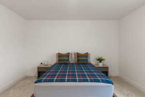 Bedroom with baseboards and light carpet