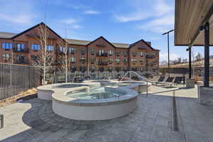 View of community featuring a patio area and a hot tub
