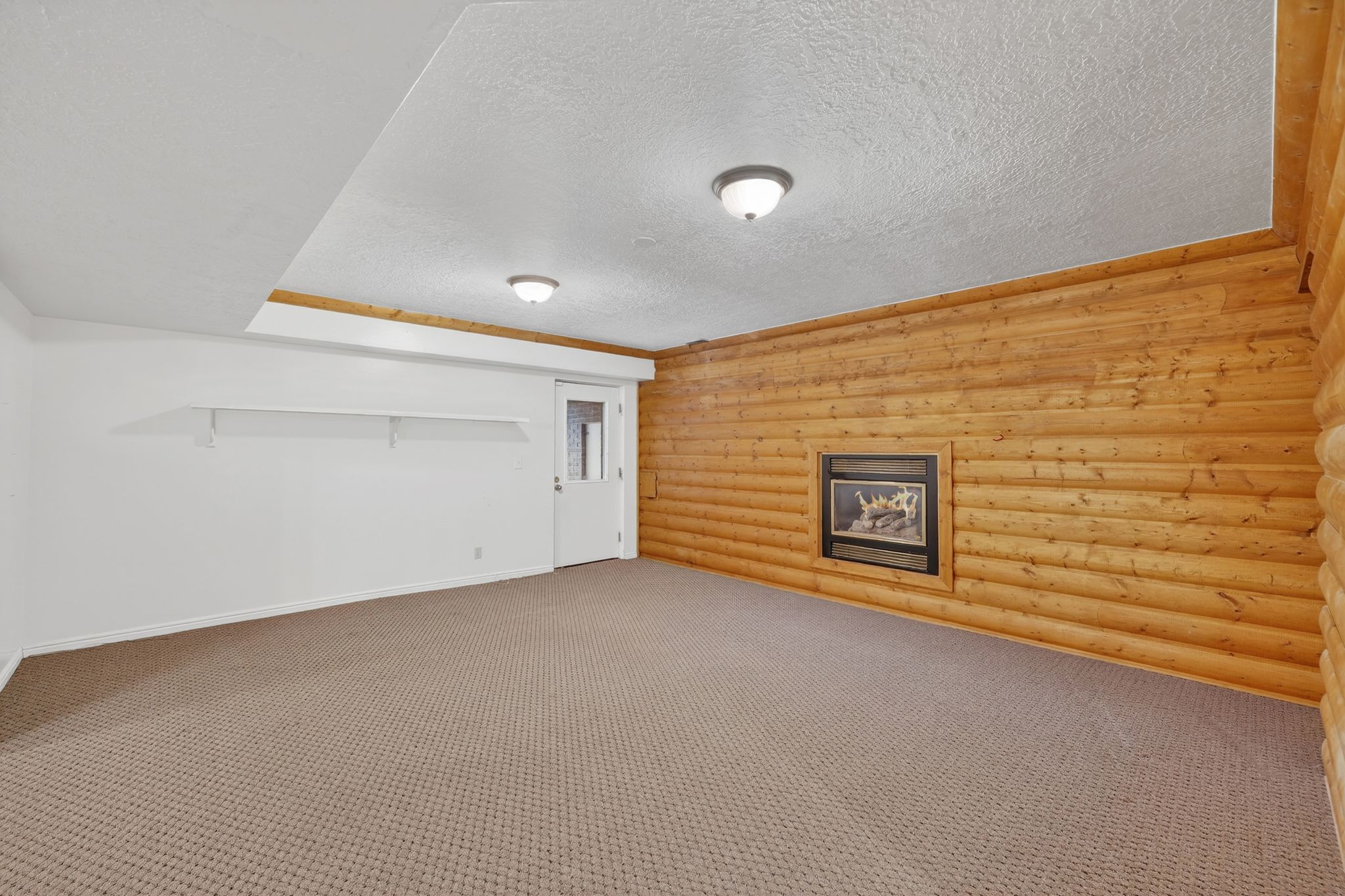 Finished basement with carpet flooring and a textured ceiling