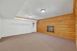 Finished basement with carpet flooring and a textured ceiling