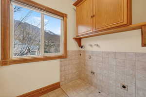 Laundry room with a mountain view, hookup for an electric dryer, cabinet space, and washer hookup