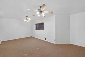 Unfurnished room featuring carpet floors and a ceiling fan
