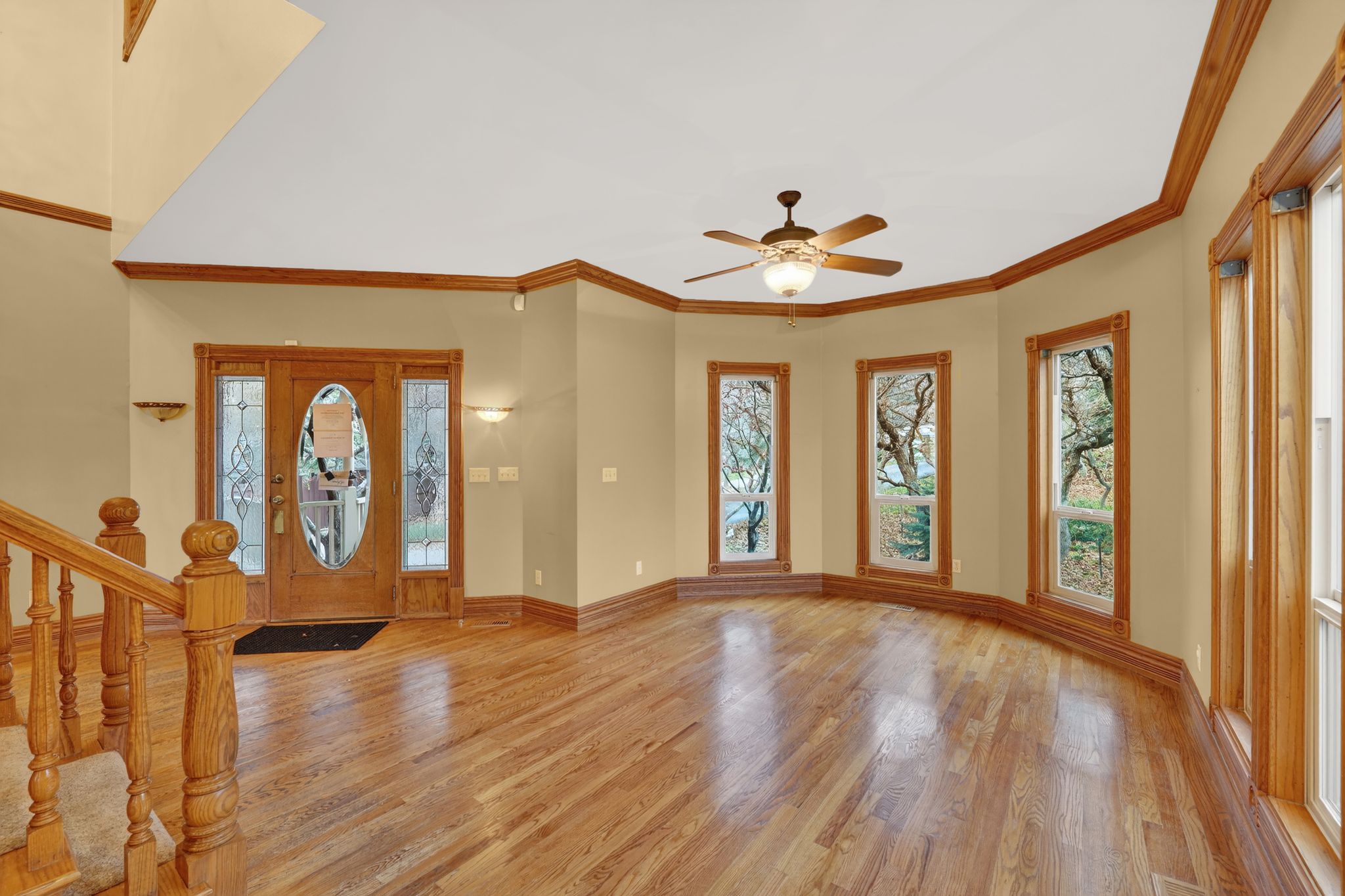 Entryway with stairway, light wood-type flooring, crown molding, and plenty of natural light
