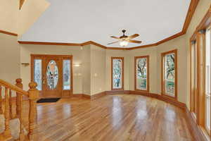 Entryway with stairway, light wood-type flooring, crown molding, and plenty of natural light