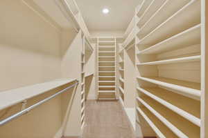 Walk in closet featuring light colored carpet