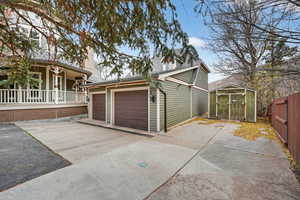 View of home's exterior featuring a garage, an outdoor structure, and concrete driveway