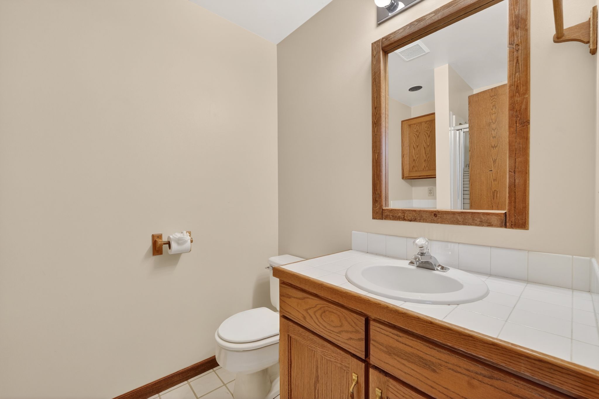 Bathroom featuring vanity, light tile patterned flooring, and curtained shower
