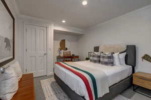 Carpeted bedroom with crown molding and recessed lighting